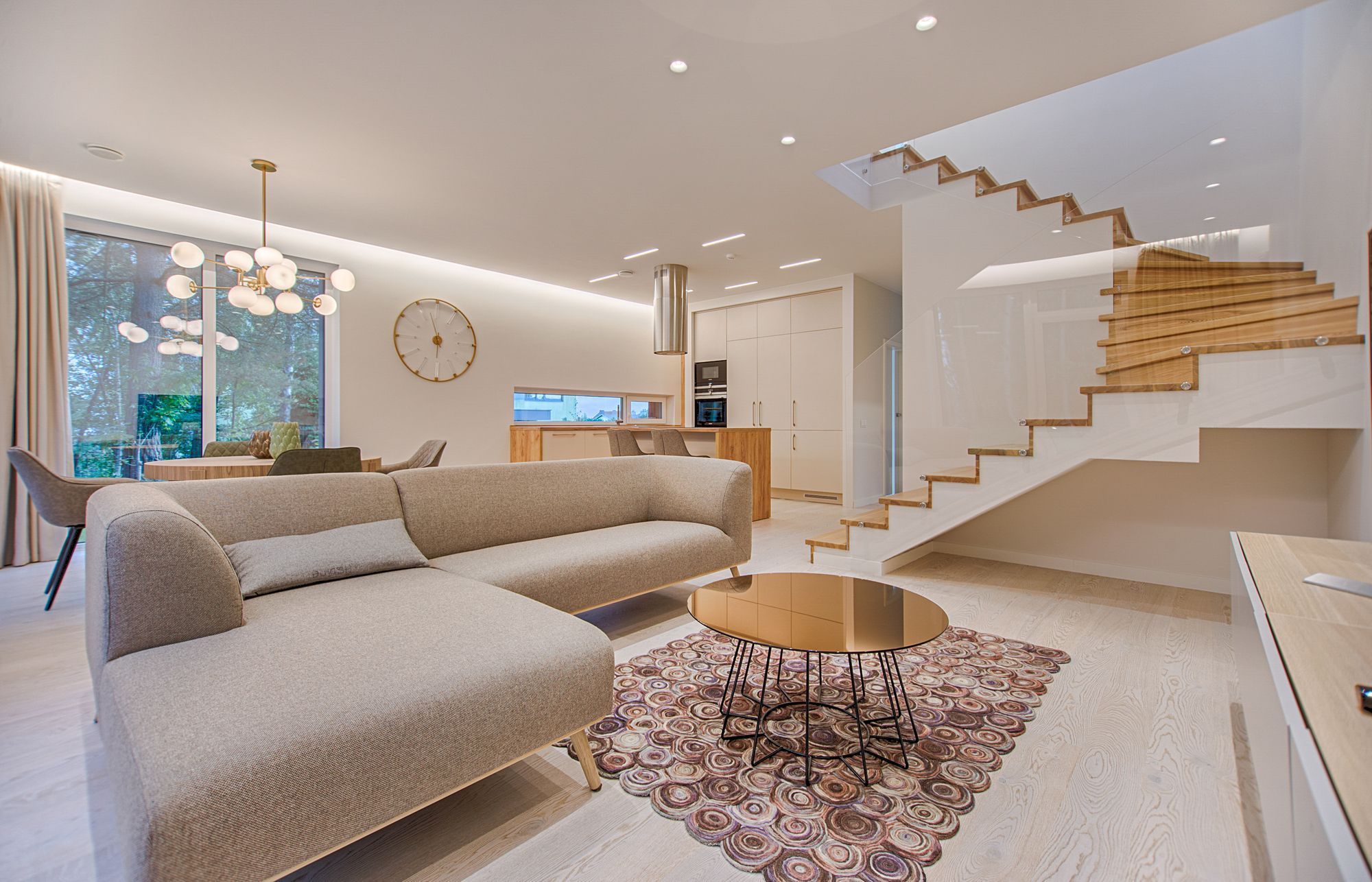 A warm, open living room with a soft greige sofa and natural light