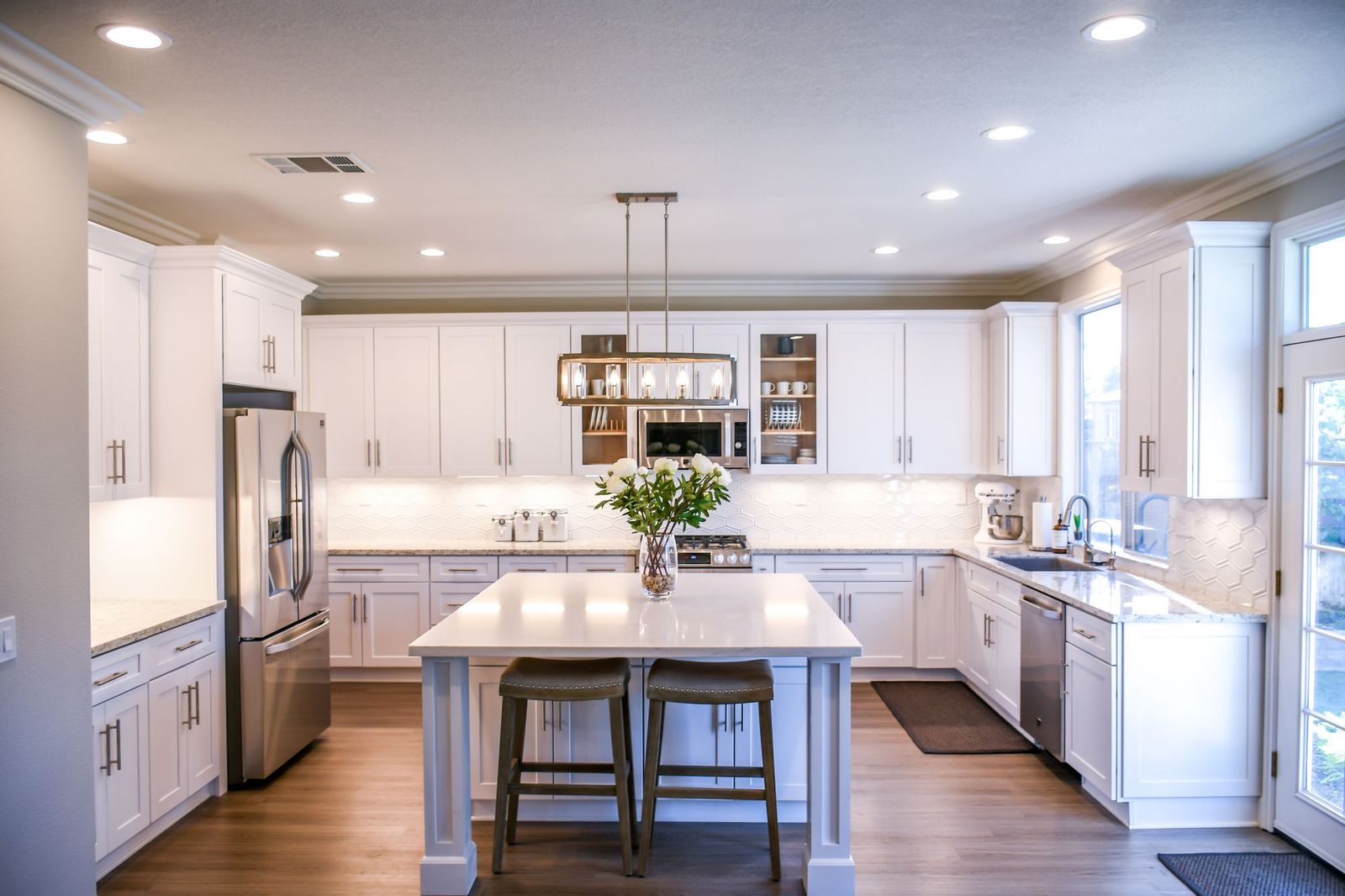 A bright, staged kitchen ready to show, with fresh flowers on the island