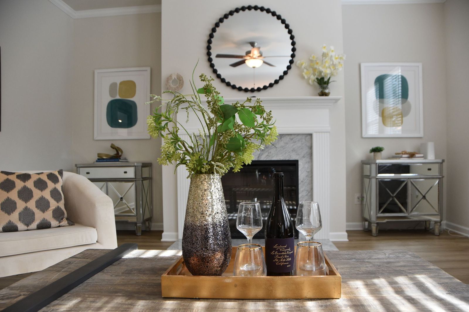 A styled decor vignette with fresh greenery, a mirror, and a mantel